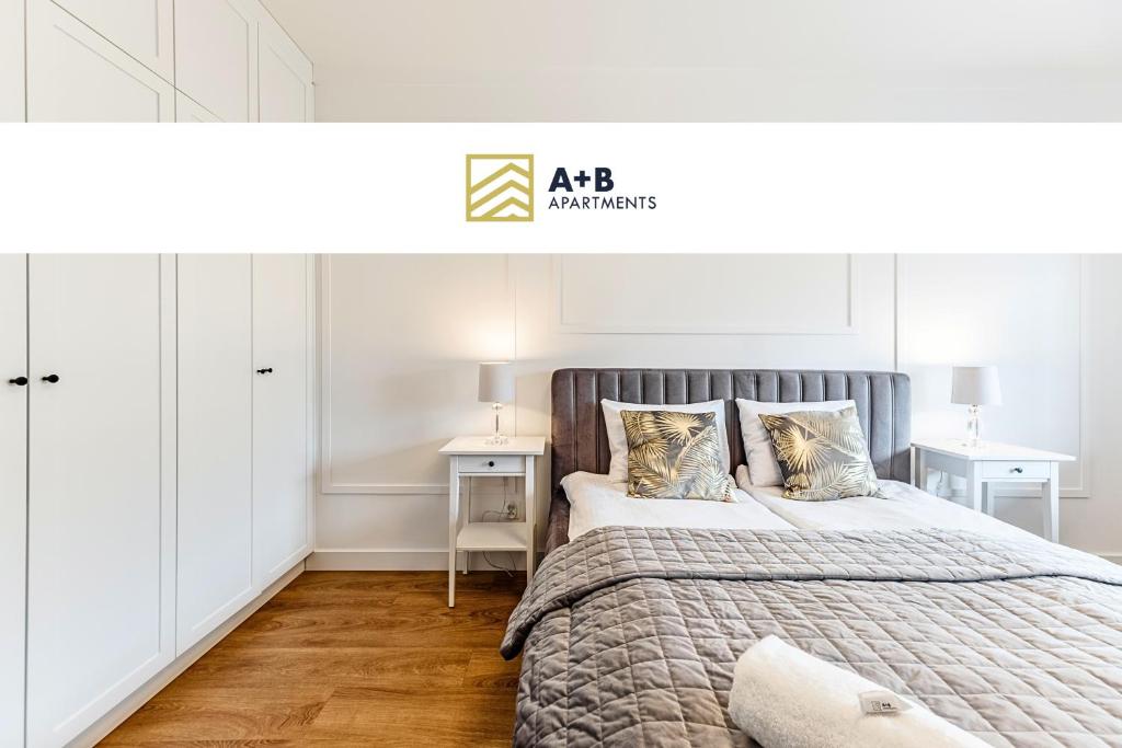 卢布林Aparthotel Plac Litewski Premium的一间白色卧室,配有一张大床和两张桌子