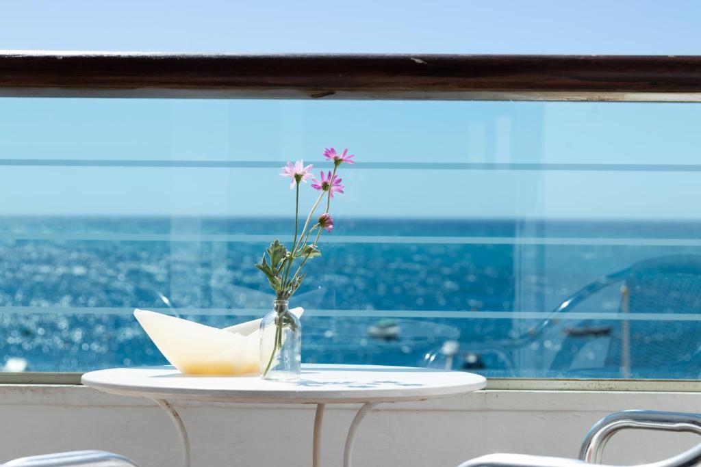 卡拉宏达格拉纳达卡拉宏达码头酒店的花瓶,在窗子的桌子上放着鲜花