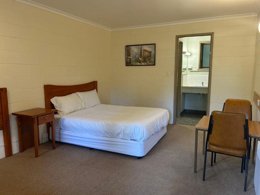 沃伯顿green gables warburton student camper accomodation的一间卧室配有一张床、一张桌子和一面镜子