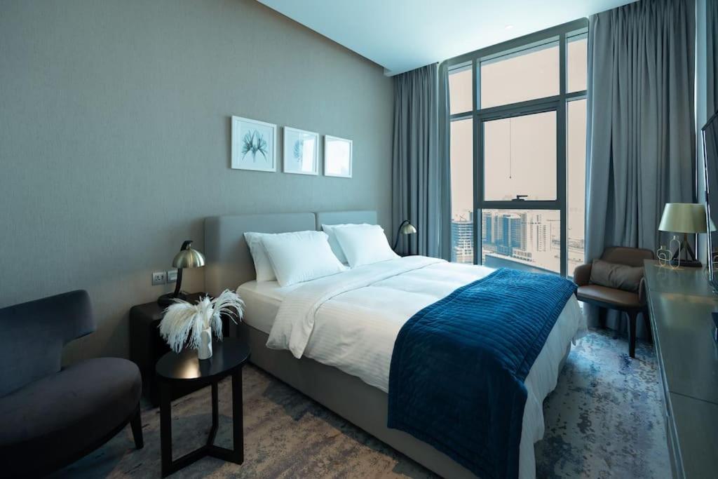 迪拜Business Bay centrally located Cozy Studio的一间卧室设有一张大床和一个大窗户