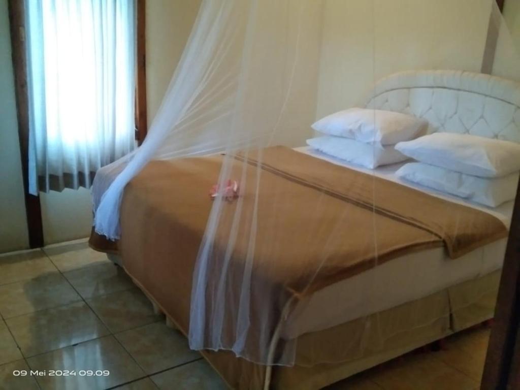 甘地达萨库拉库拉别墅的一间卧室配有带白色床单和枕头的床。