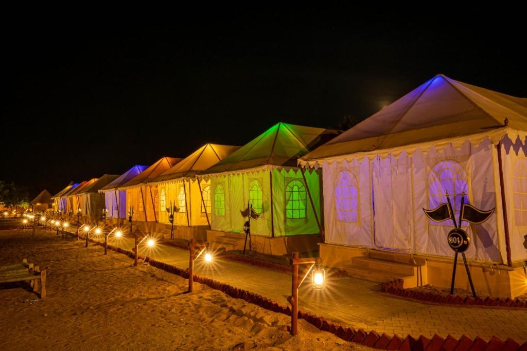 斋沙默尔Jaisalmer Night Safari Camp的夜晚一排带灯的帐篷