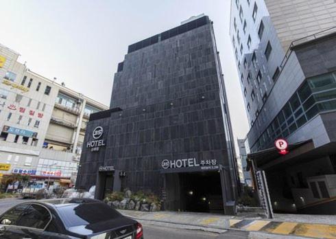 仁川市3S Hotel Sorae的停在街道上建筑物前面的汽车