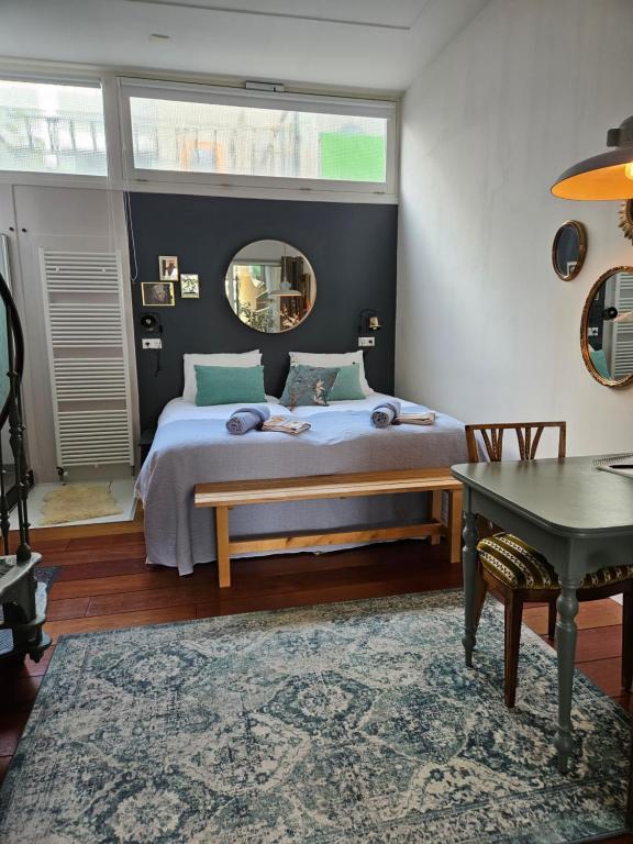 阿姆斯特丹Waterfront Studio的一间卧室配有一张床、一张桌子和一面镜子