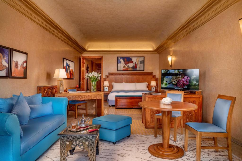 马拉喀什居萨阿迪马拉喀什宫殿度假酒店的客厅配有蓝色的沙发和床。