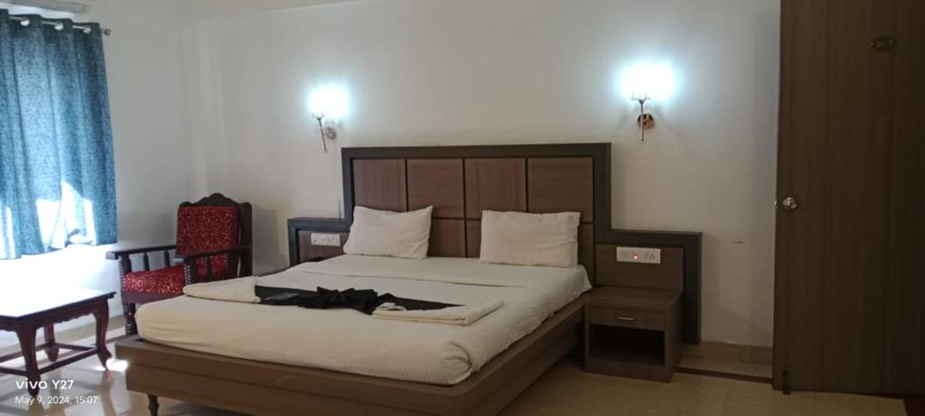 钦奈Mount Heera Hotel-Alandur的一间卧室配有一张大床和木制床头板