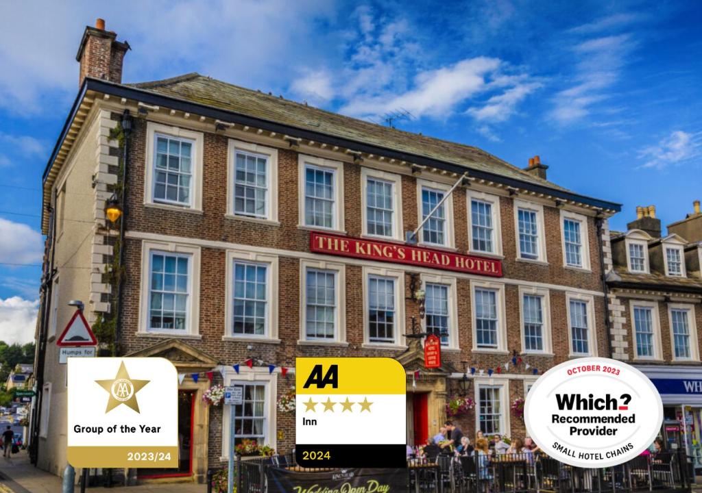 里士满The Kings Head Hotel, Richmond, North Yorkshire的一座大型砖砌建筑,前面有标志