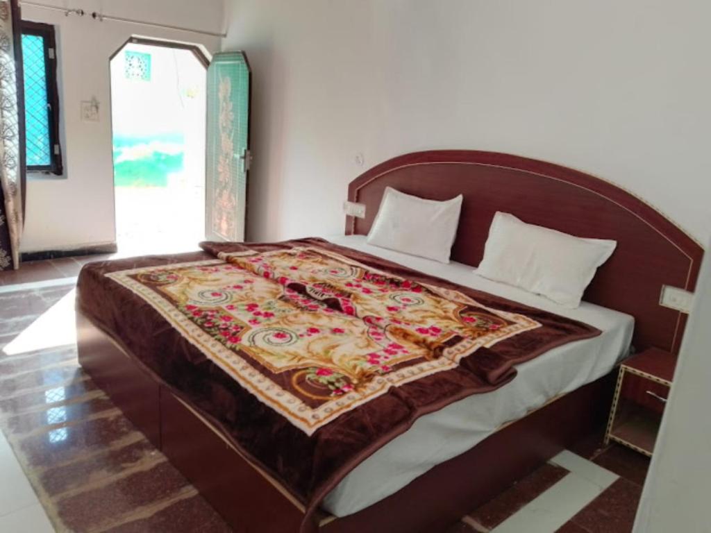 克久拉霍Goroomgo Hotel Happy Home Stay Khajuraho的一间卧室配有一张大床,床上有毯子