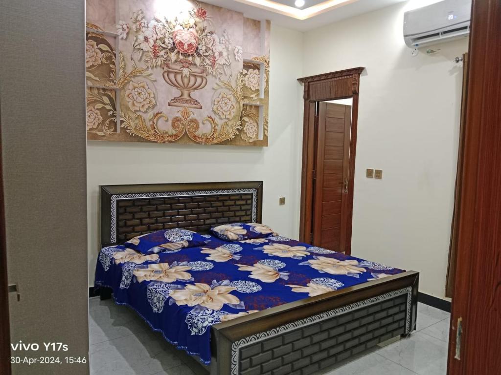 JhelumShah jee guest house的一间卧室配有一张带蓝色棉被的床