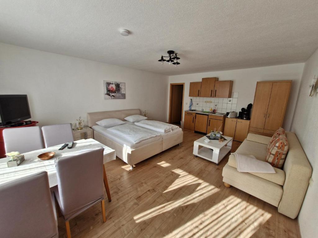 伊尔梅瑙Ferienwohnung Schulzental的一间卧室配有一张床、一张桌子和一张沙发