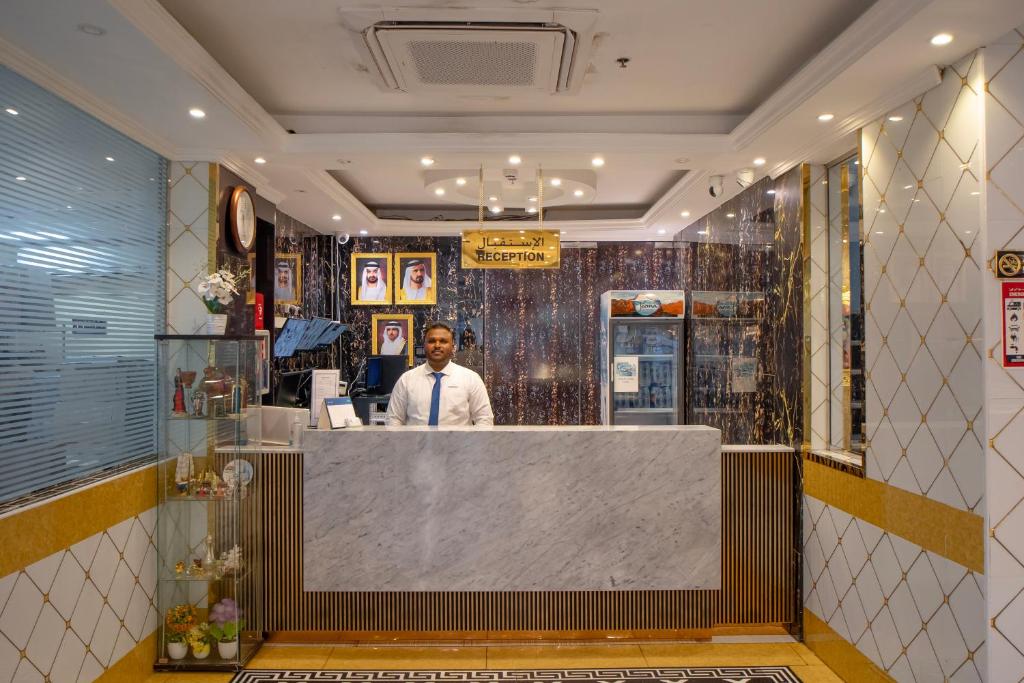 迪拜AL KARNAK HOTEL - BRANCH的站在餐厅柜台上的人