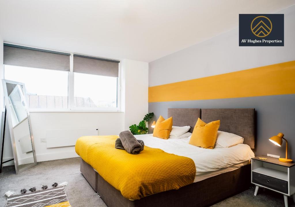 米尔顿凯恩斯Modern One Bedroom Apartment by AV Hughes Properties Short Lets & Serviced Accommodation Milton Keynes - For Couples & Leisure的一间卧室配有一张带黄色枕头的大床