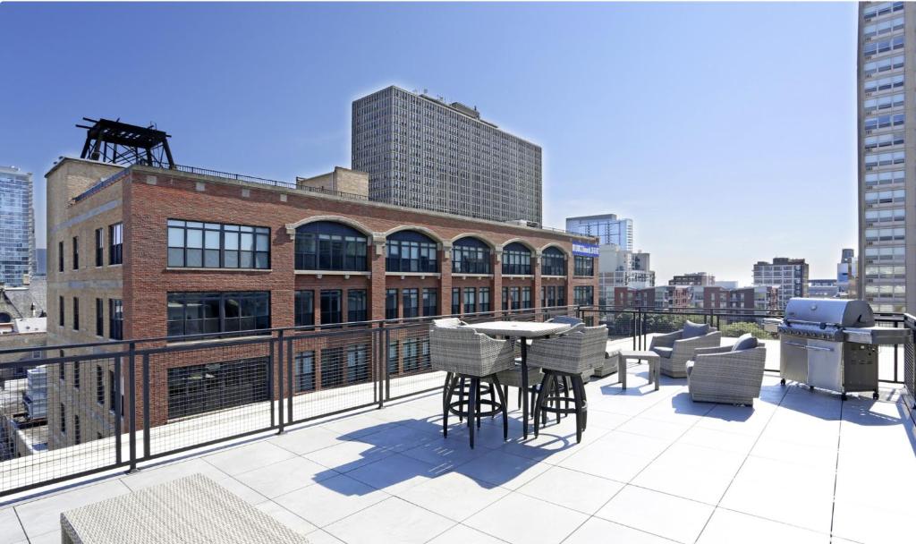 芝加哥Modern 2BR in South Loop Near Soldier Field, Grant Park, Downtown, &amp; Lakefront Trail的建筑物上的带桌椅的阳台