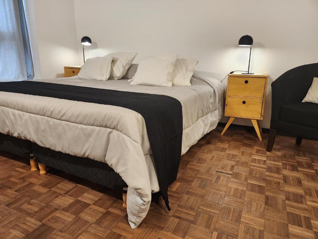 科尔多瓦Hermoso Apartamento en Edificio Saint Michel的一间卧室配有一张大床和一把椅子