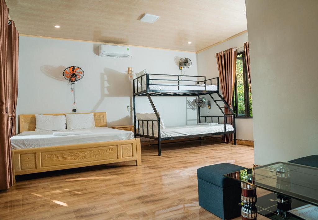 吉婆岛Tran Chau Garden Home的一间带两张双层床和一张沙发的卧室