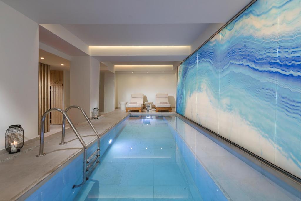 雅典The Residence Christokopidou Hotel & Spa的墙上有大画的游泳池