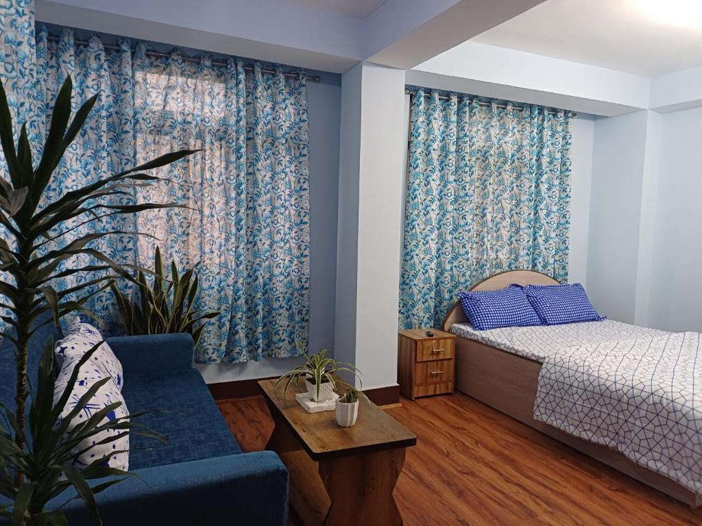 甘托克Bluebird'snest的一间卧室配有一张床、一张沙发和一张桌子