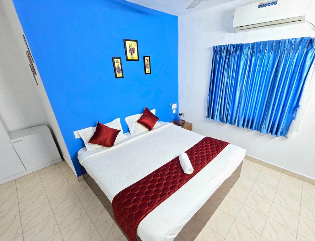 蓬蒂切里SEA WALK Serenity beachside的蓝色卧室配有一张带红色枕头的大床
