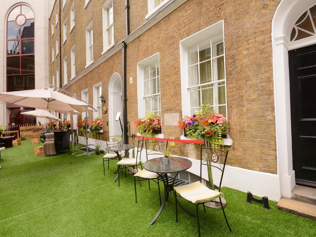 伦敦Montcalm Brewery Townhouse的庭院配有桌椅和鲜花