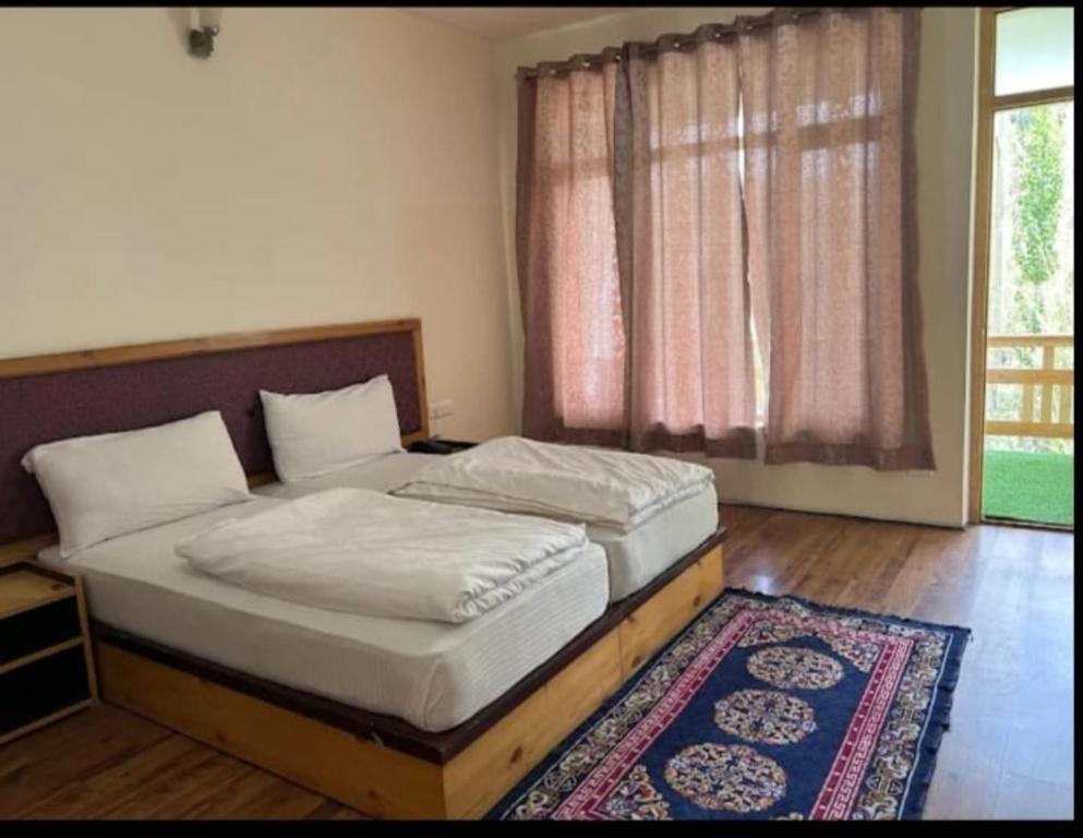 列城Ewam Chunka的一间卧室设有两张床,窗户铺有地毯。