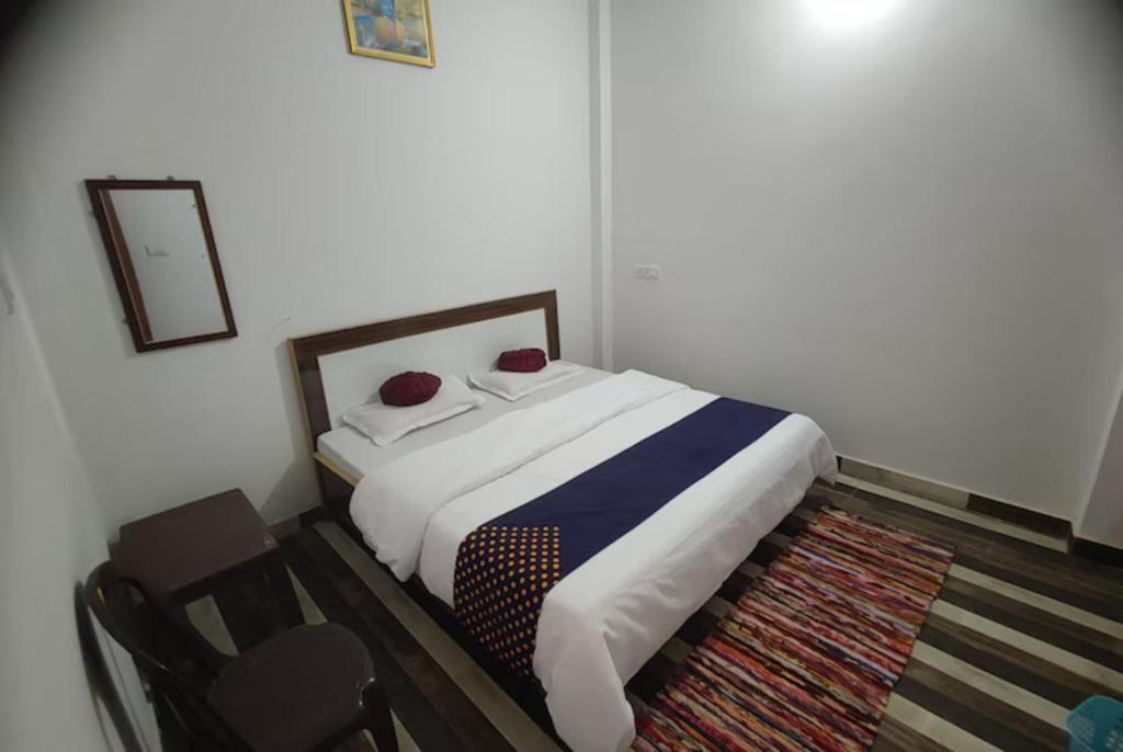 瓦拉纳西Goroomgo Hotel Kashi Nest Varanasi - A Peacefull Stay & Parking Facilities的一间卧室配有一张床和一把椅子