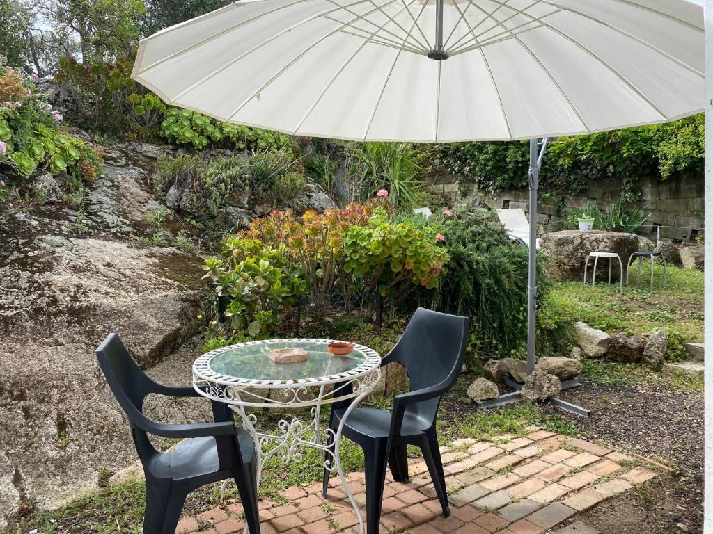 维琪奥港chez Béatrice的一张桌子和两把椅子以及一把雨伞
