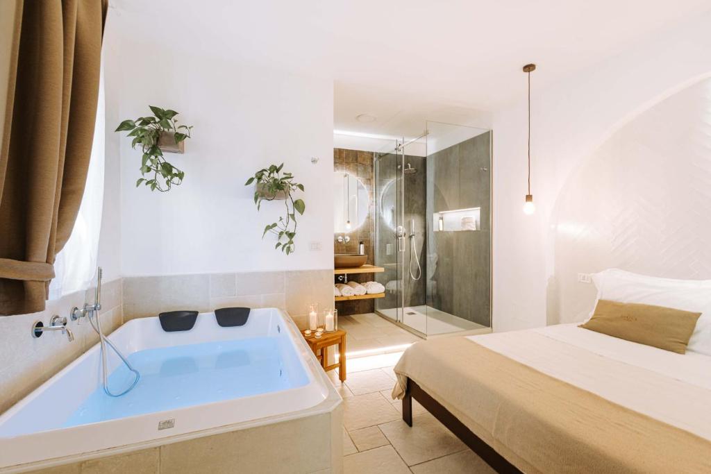 莫诺波利Dirium - exclusive rooms的一间位于床边的带浴缸的浴室