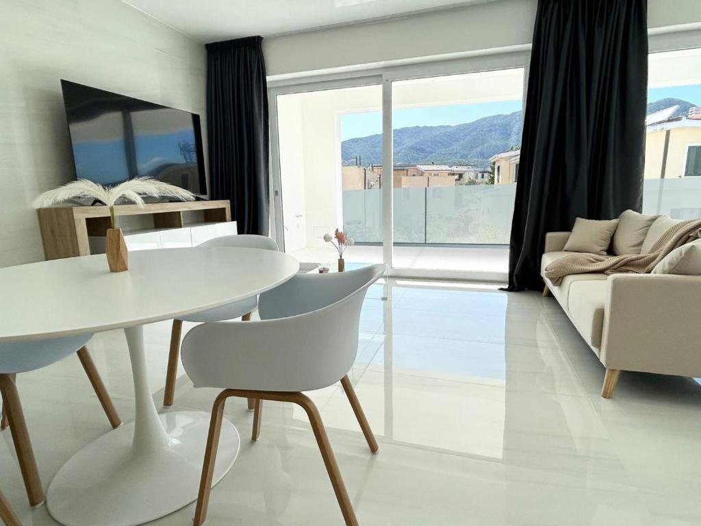 奥罗塞伊Smart Luxury Suites & Apartments的客厅配有白色的桌子和椅子