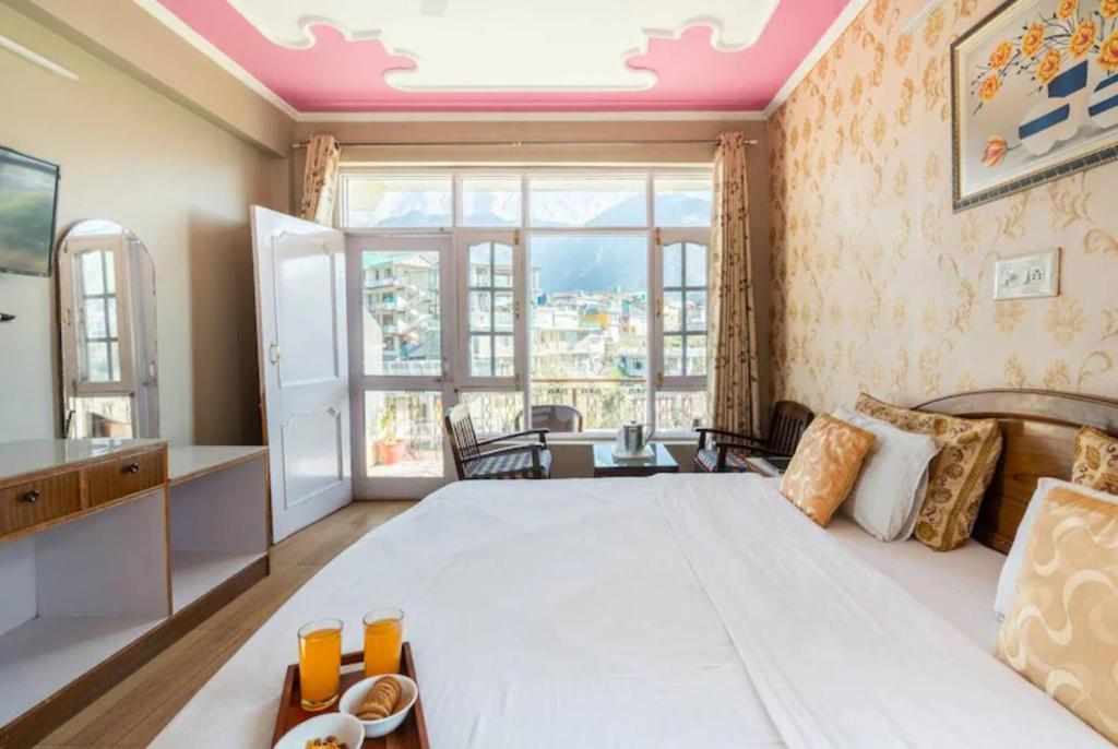 达兰萨拉Hotel Snow Crest Inn - Natural landscape Mountain View的一间卧室设有一张大床和一个大窗户