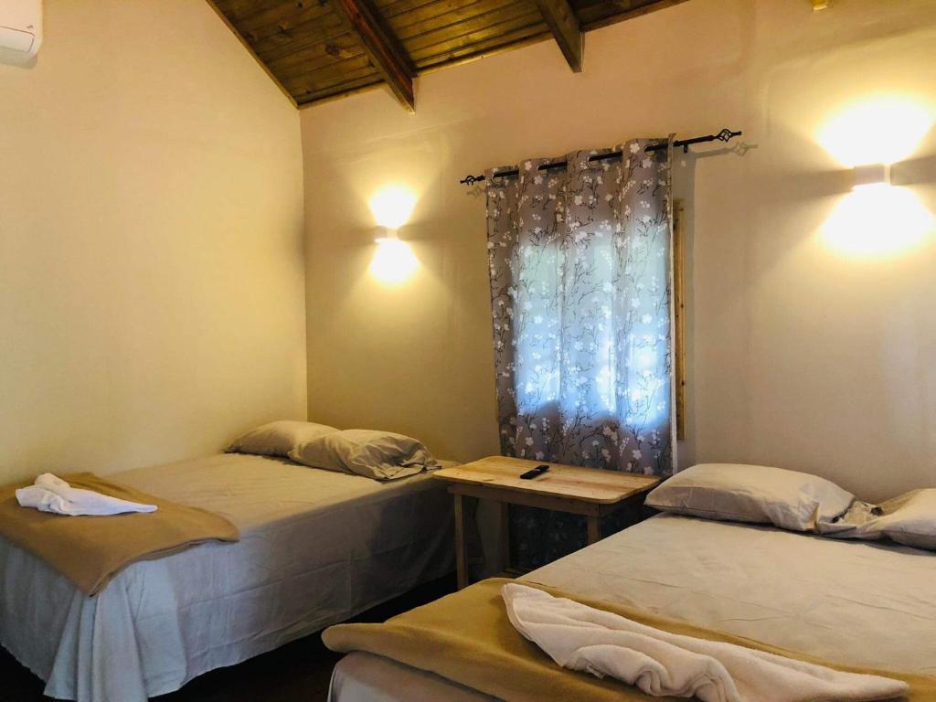 圣克鲁斯德约霍阿Cabaña de campo en el lago de yojoa的带窗户的客房内设有两张单人床。