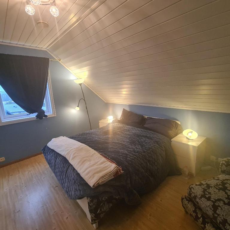 斯塔万格GG overnatting的一间卧室配有一张床、两盏灯和一个窗户。