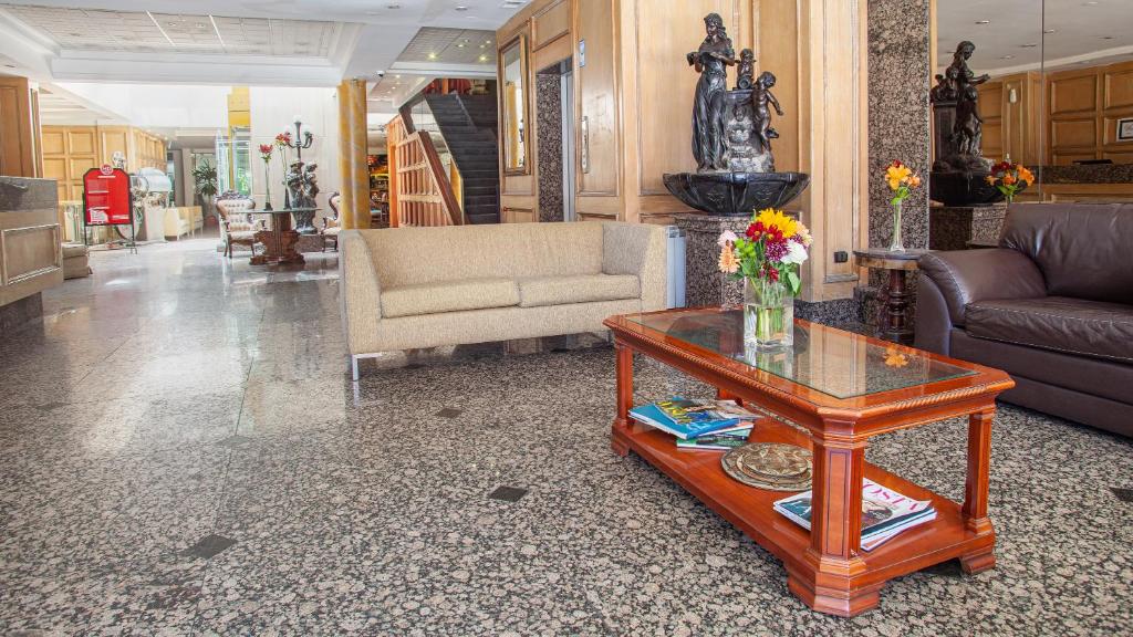 康塞普西翁HOTEL EL DORADO的客厅配有桌子和沙发