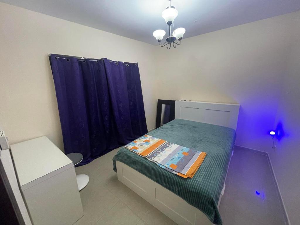 迪拜1 Bedroom Sanctuary Al Ghurair Mall的一间卧室配有一张床和蓝色的灯光