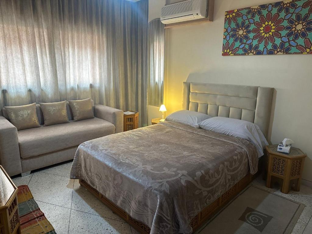 马拉喀什Appartement Wassim - Gueliz的一间卧室配有一张床和一张沙发