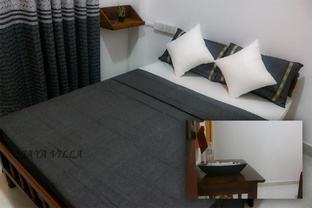 尼甘布Jaya Villa的一张带枕头的床铺和一张桌子