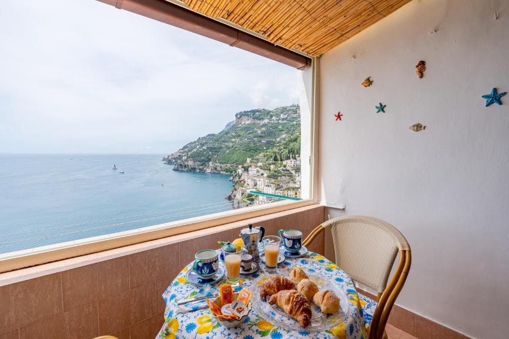 米诺利Casa Maria Vittoria的一张桌子,从窗口可欣赏到海景