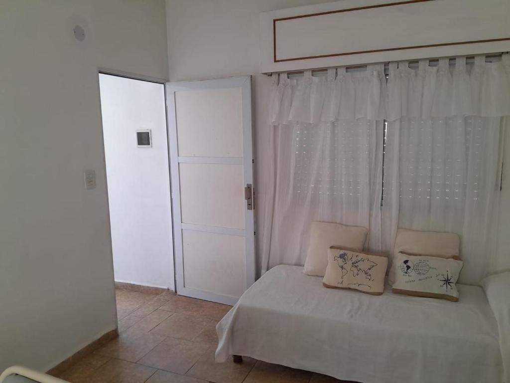 GualeguaychúMilli的卧室配有带白色窗帘的床和窗户。