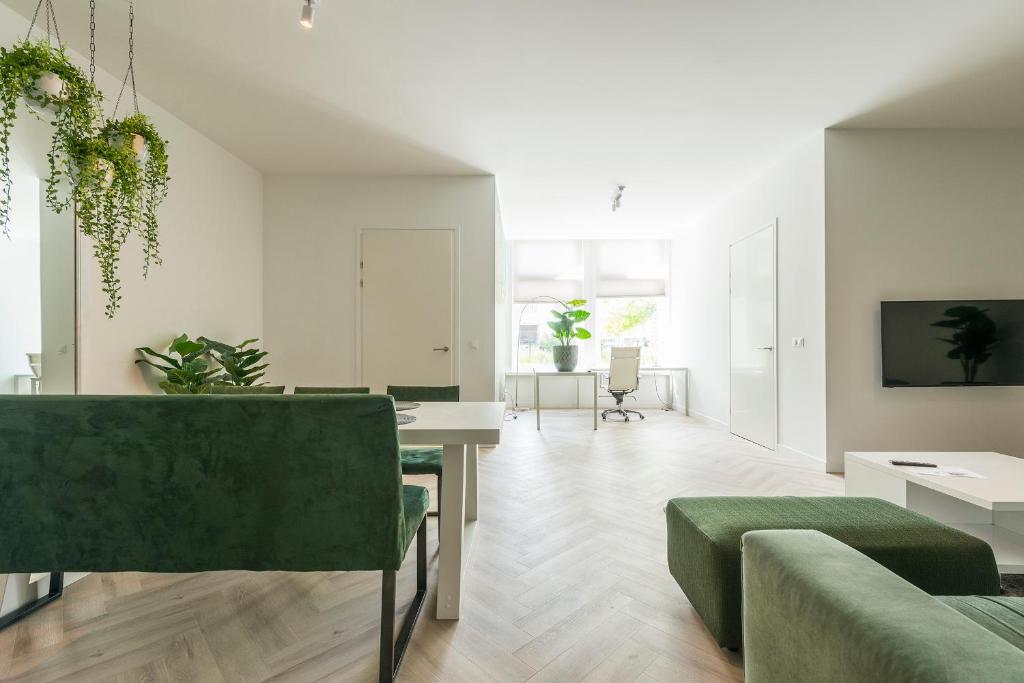罗森达尔New Luxurious Apartment With 2 Bedrooms & Garden的客厅配有绿色沙发和桌子