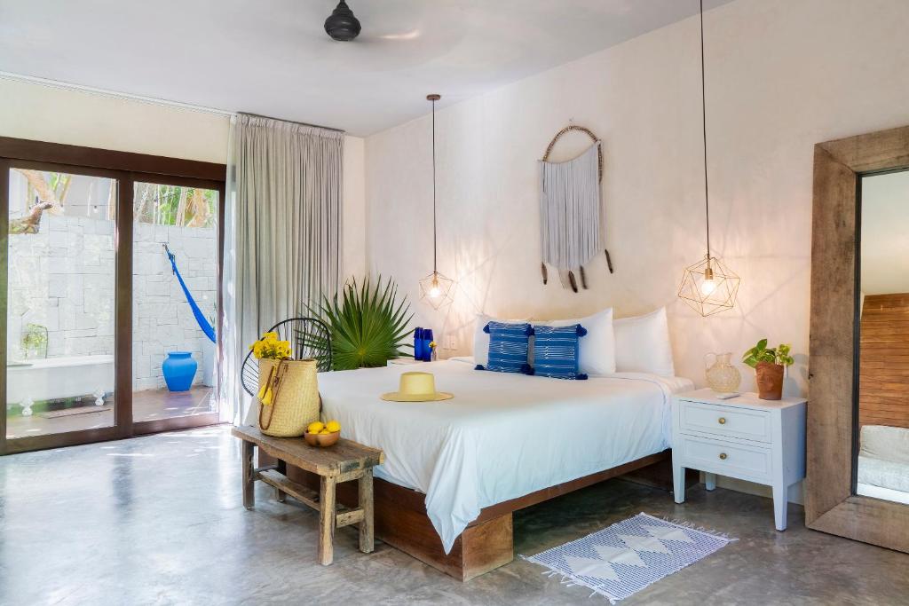 图卢姆Lula Seaside Boutique Hotel的卧室配有带蓝色枕头的大型白色床