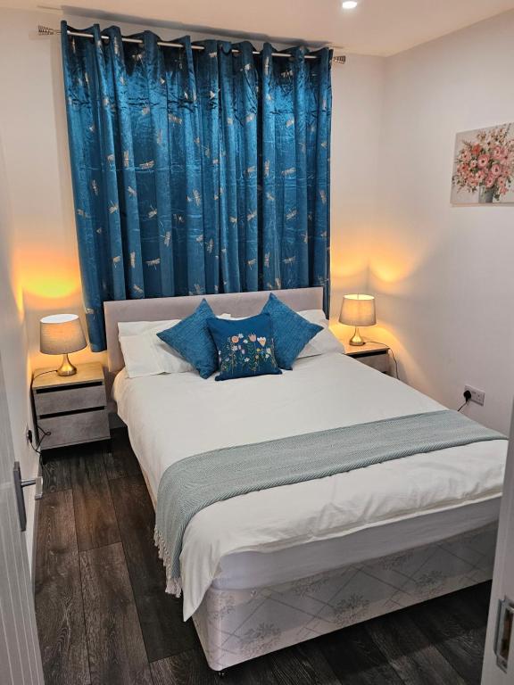 芬奇利Private One Bedroom Flat in Barnet, London的一间卧室配有一张带蓝色窗帘的大床