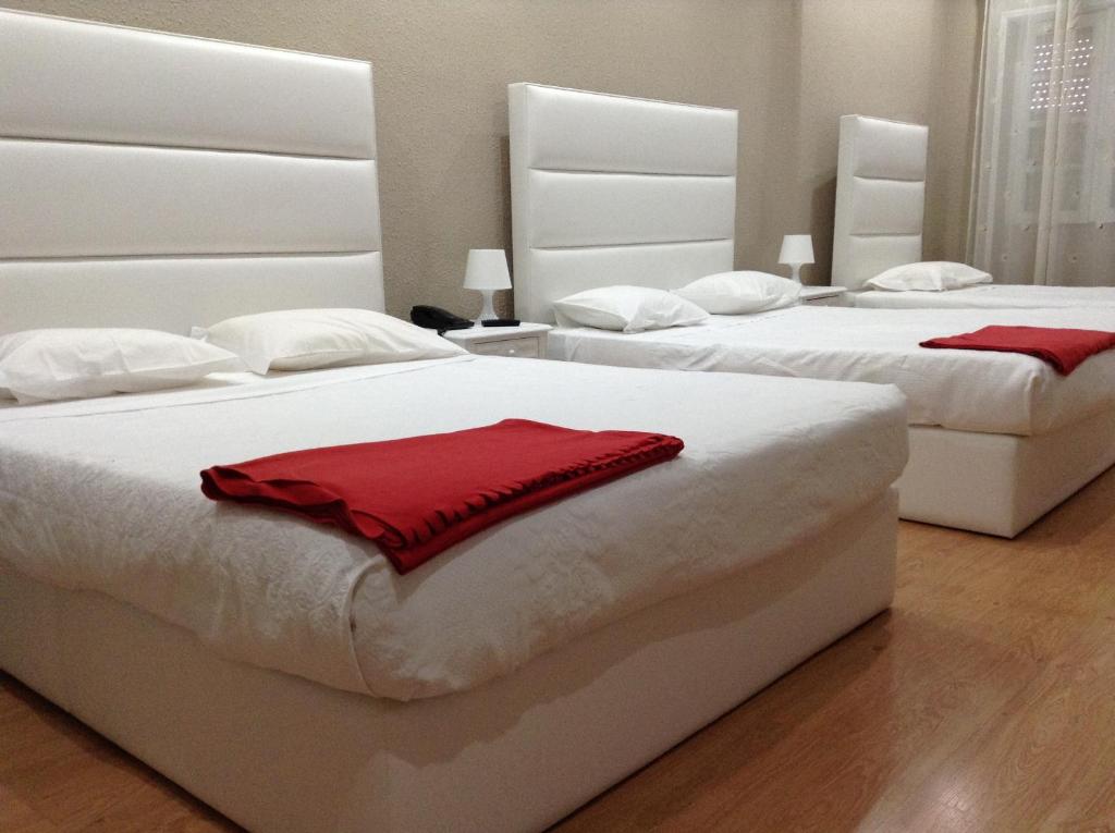 波尔图Royal Porto City的一间卧室配有两张带红色毛巾的床。