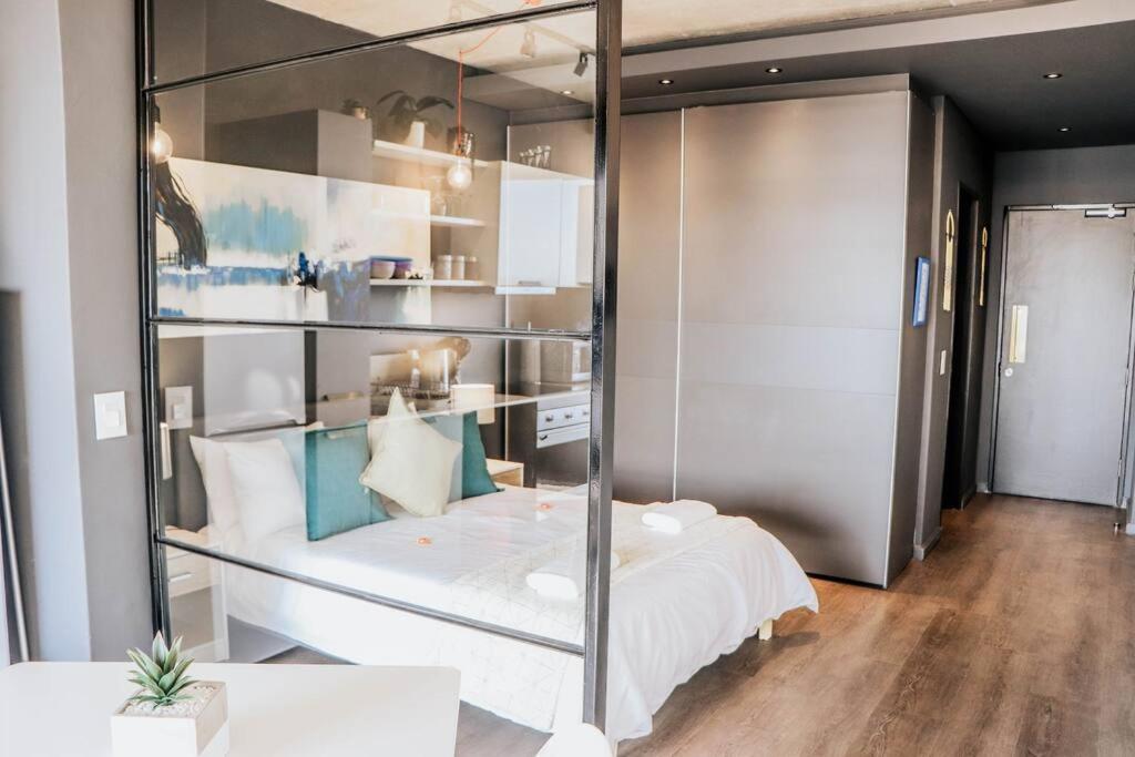 开普敦Modern Wex 831的一间设有一张玻璃墙床的房间