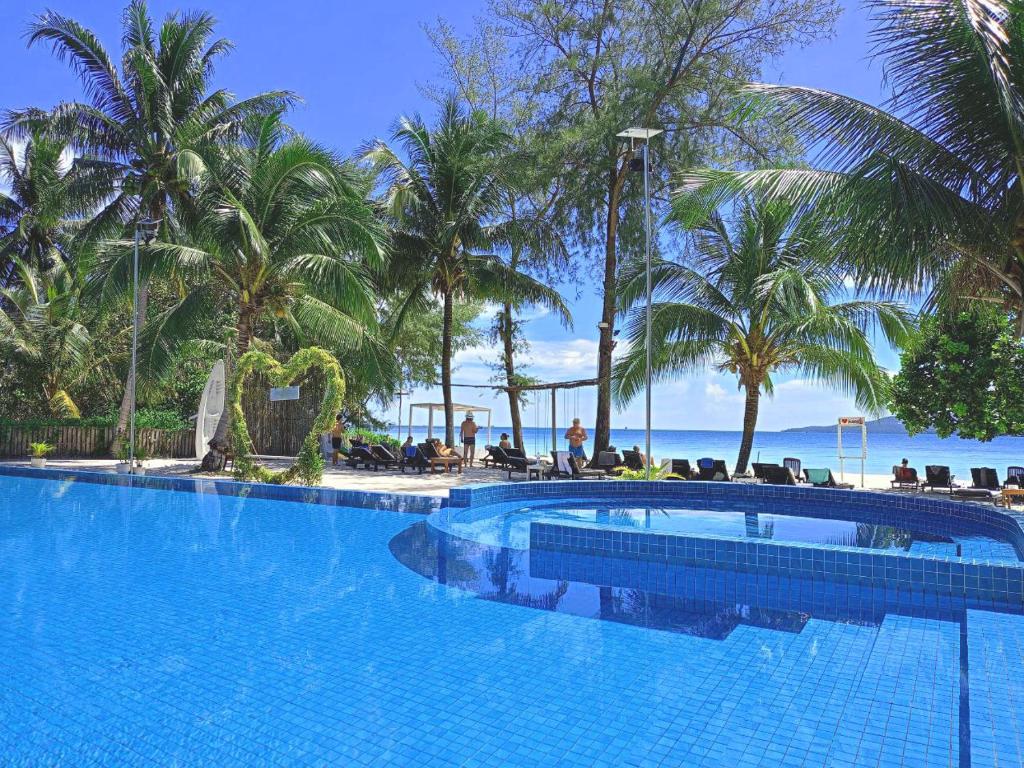 瓜隆岛SCARLET SAILS BUNGALOW的一座棕榈树和海洋的大型游泳池
