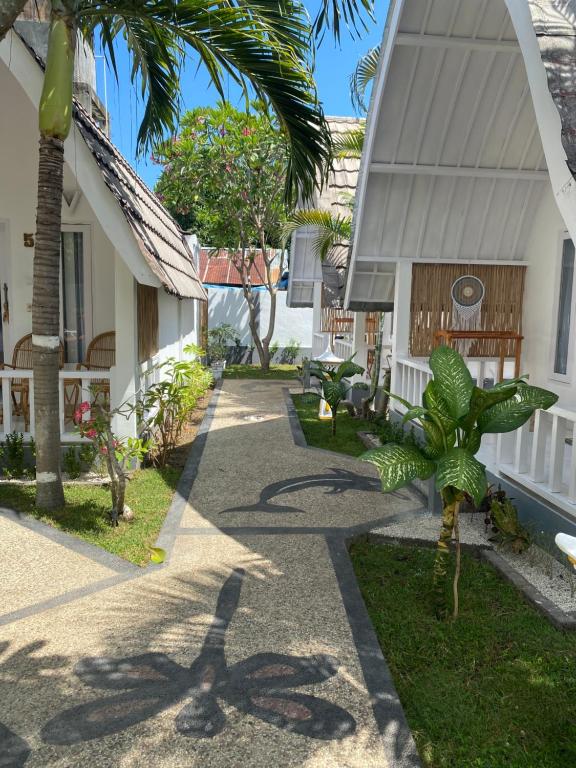 吉利阿尔New Balengkudua Hotel的棕榈树屋前的走道