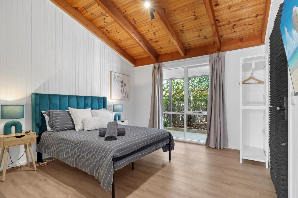 吉朗Recharge in Waurn Ponds的一间卧室设有一张床和木制天花板