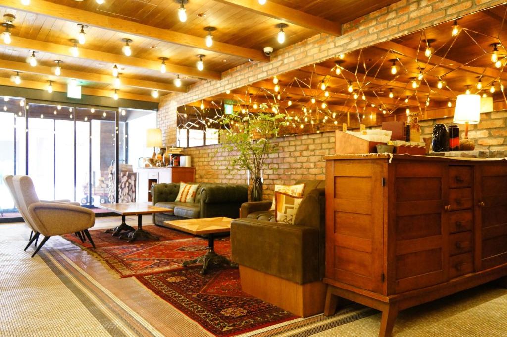 札幌UNWIND Hotel & Bar Sapporo的客厅配有沙发和桌椅