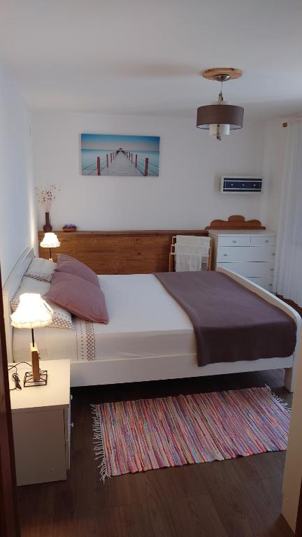 普纳特da Dorian的一间卧室配有一张大床和一张带台灯的桌子