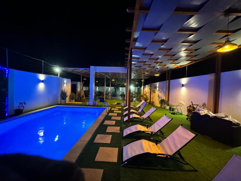 普拉亚Pereira lounge bar的游泳池旁的躺椅,晚上