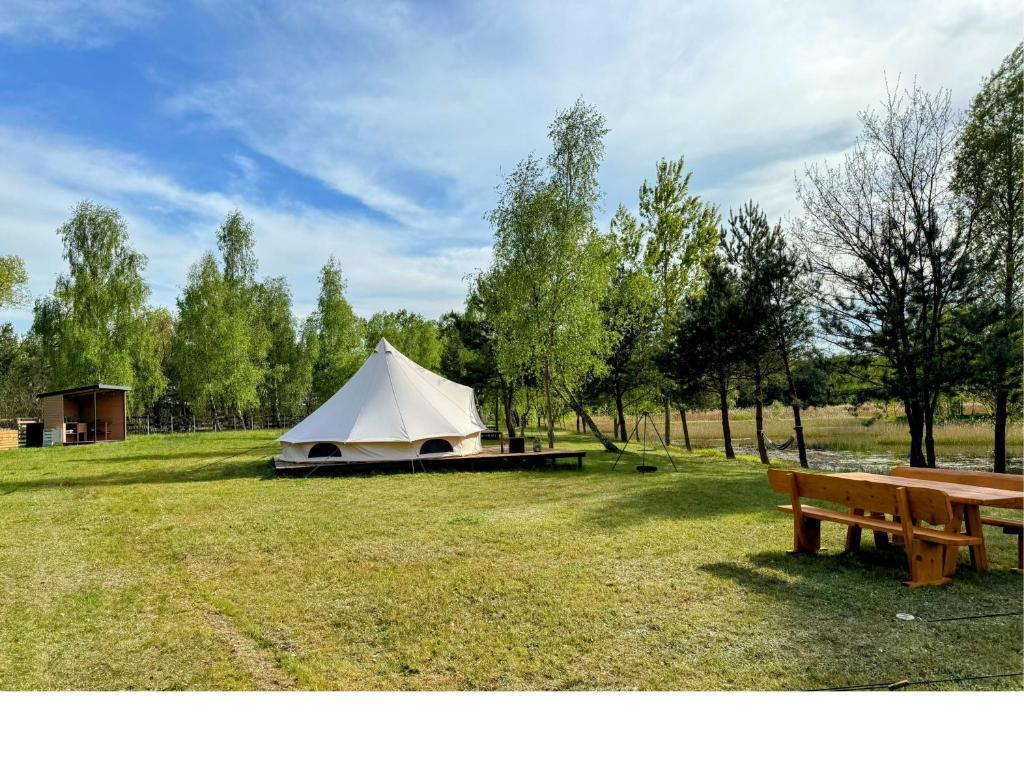 ChocianówGlampine的田野上的白色帐篷,带长凳