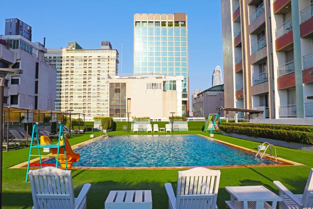 曼谷Evergreen Place Siam by UHG的城市里一个带椅子的游泳池和一个游乐场